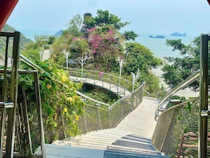 A staircase leading to a scenic overlook with a view of the sea and distant islands. - Forest Sky Villa - Flamingo Cat Ba (Cat Hai)