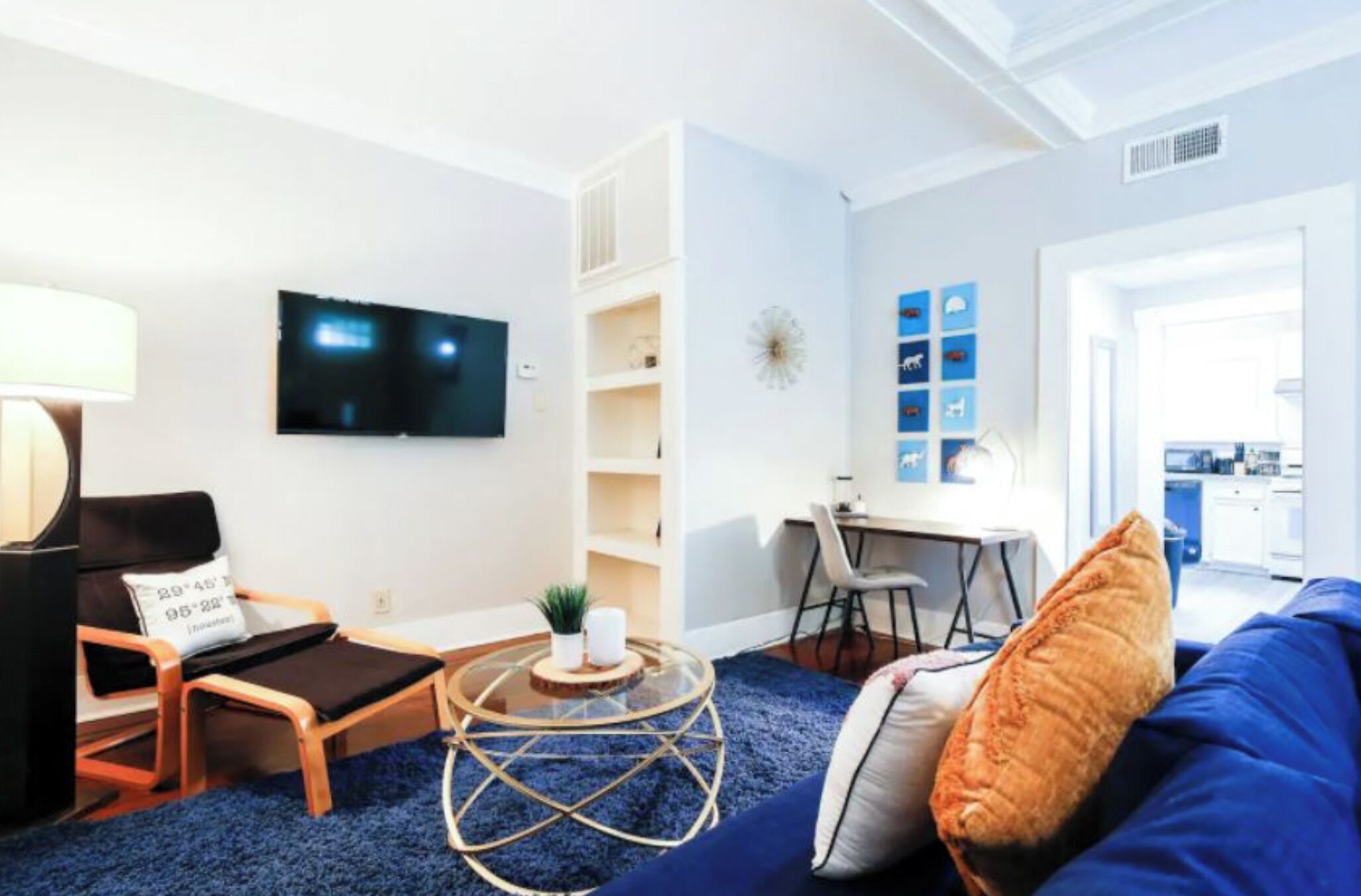 A modern living room with a TV, a round coffee table, a sofa, and a dining area.