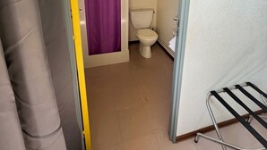 A bathroom with a toilet, a shower curtain, and a towel rack. - Welcome to Auberge les Clarisses with its relaxation area, communal kitchen (Gourdon)