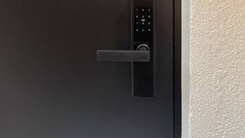 A modern door with a keypad lock and a horizontal handle.