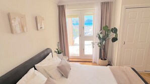 A bedroom with a bed, a potted plant, and a view through a door. - Luxury Beach Villa, Sibenik, 4 Stars (Brodarica)