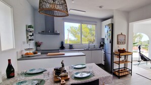 Una cucina moderna con zona pranzo, ampie finestre e vista sull'esterno.
