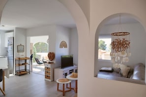 A modern living room with a TV, seating area, and a hanging light fixture. - Villa Amira - Altea, Costa Blanca (Altea)