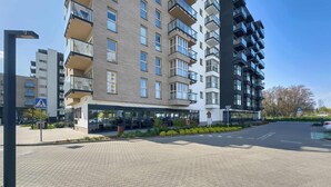A multi-story residential building with balconies, a pedestrian crossing sign, and a parking sign. - Bright Apartment | Parking | Balcony | Remote Work (Poznań)