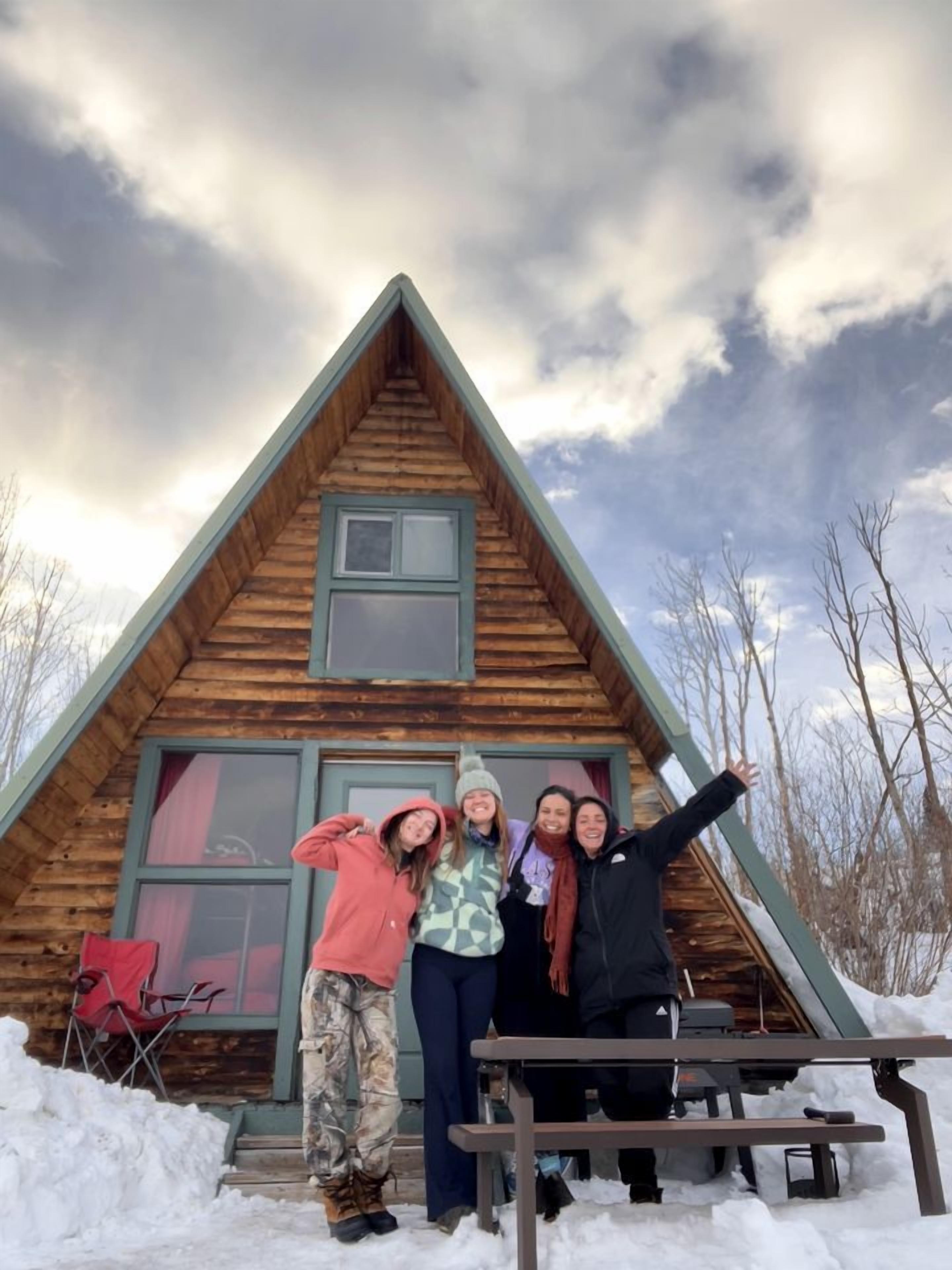 A wooden cabin with a pitched roof, a small window, and a door.