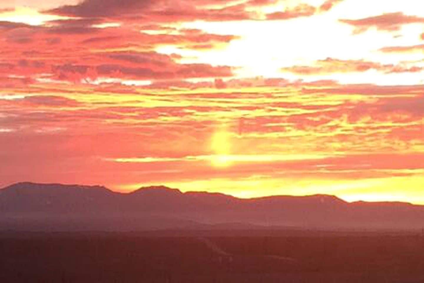 A sunset over a mountainous landscape.