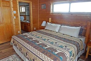 A wooden room with a bed, a window, and a door. - Cabin Rental for Large Groups Ideal for Colorado Glamping (Walden)