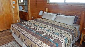A wooden room with a bed, a window, and a door. - Cabin Rental for Large Groups Ideal for Colorado Glamping (Walden)