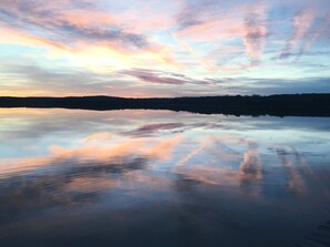 A calm lake reflecting the sky during sunset. - Charming Lakeside Cabin with Fire Pit & Private Dock Near Lake Cisco, Cisco, TX (Cisco)