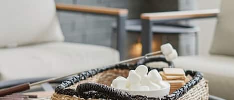 En fletkurv med marshmallows og en chokoladebar på et bord.