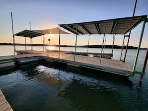 A dock with a covered seating area and a small pool.