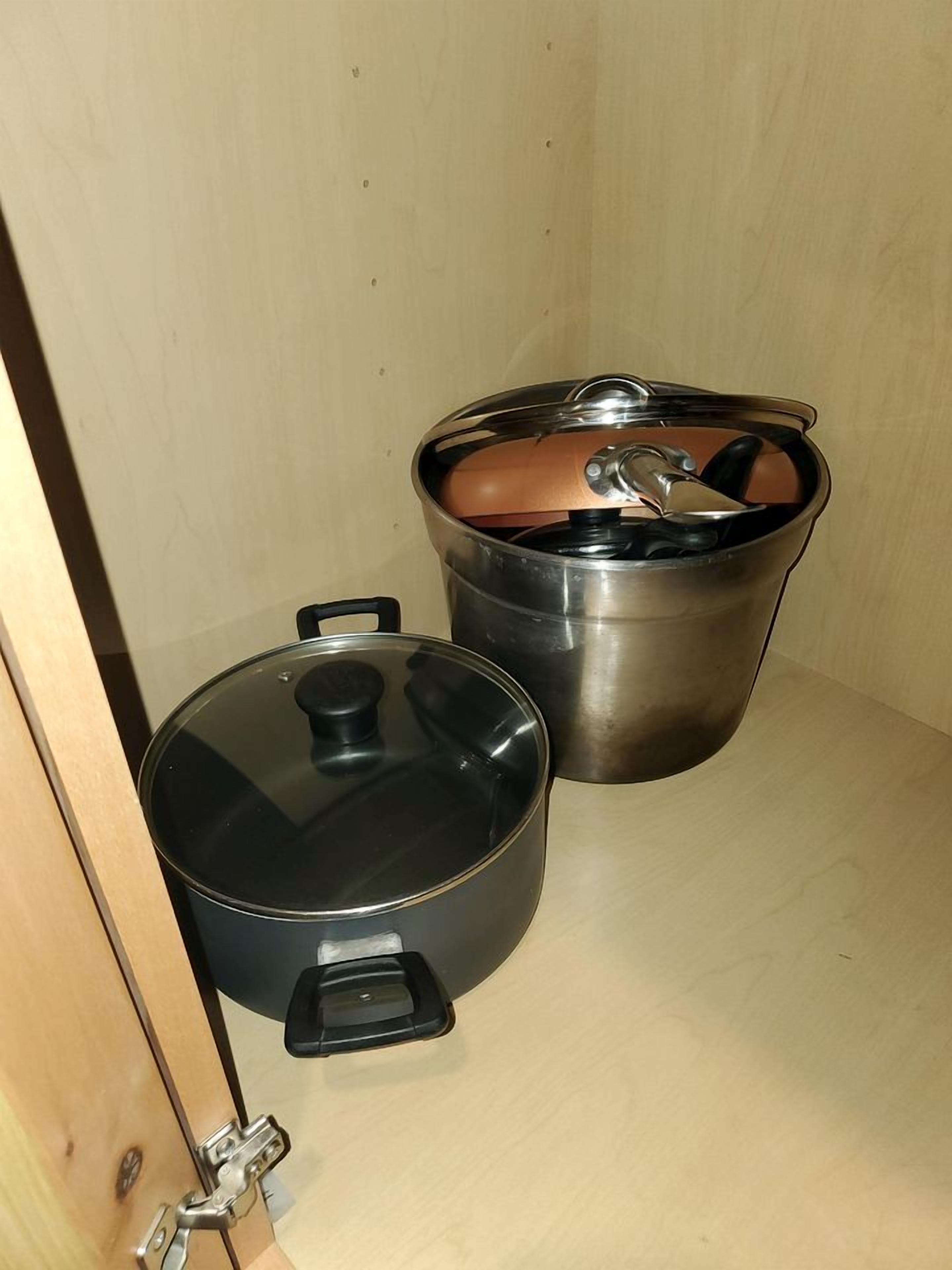 Deux casseroles en acier inoxydable, munies de couvercles, posées sur une surface en bois.