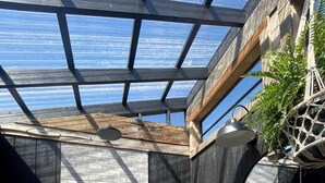 A modern interior with a skylight, a brick wall, and a wooden bench.