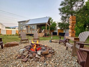 Ein Haus mit Feuerstelle, Sitzgelegenheiten im Freien und einer Terrasse.