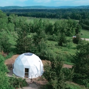 Una estructura geodèsica en una zona boscosa amb una vista clara del paisatge circumdant.