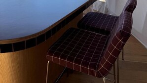 A tent with a wooden bar and checkered seating.