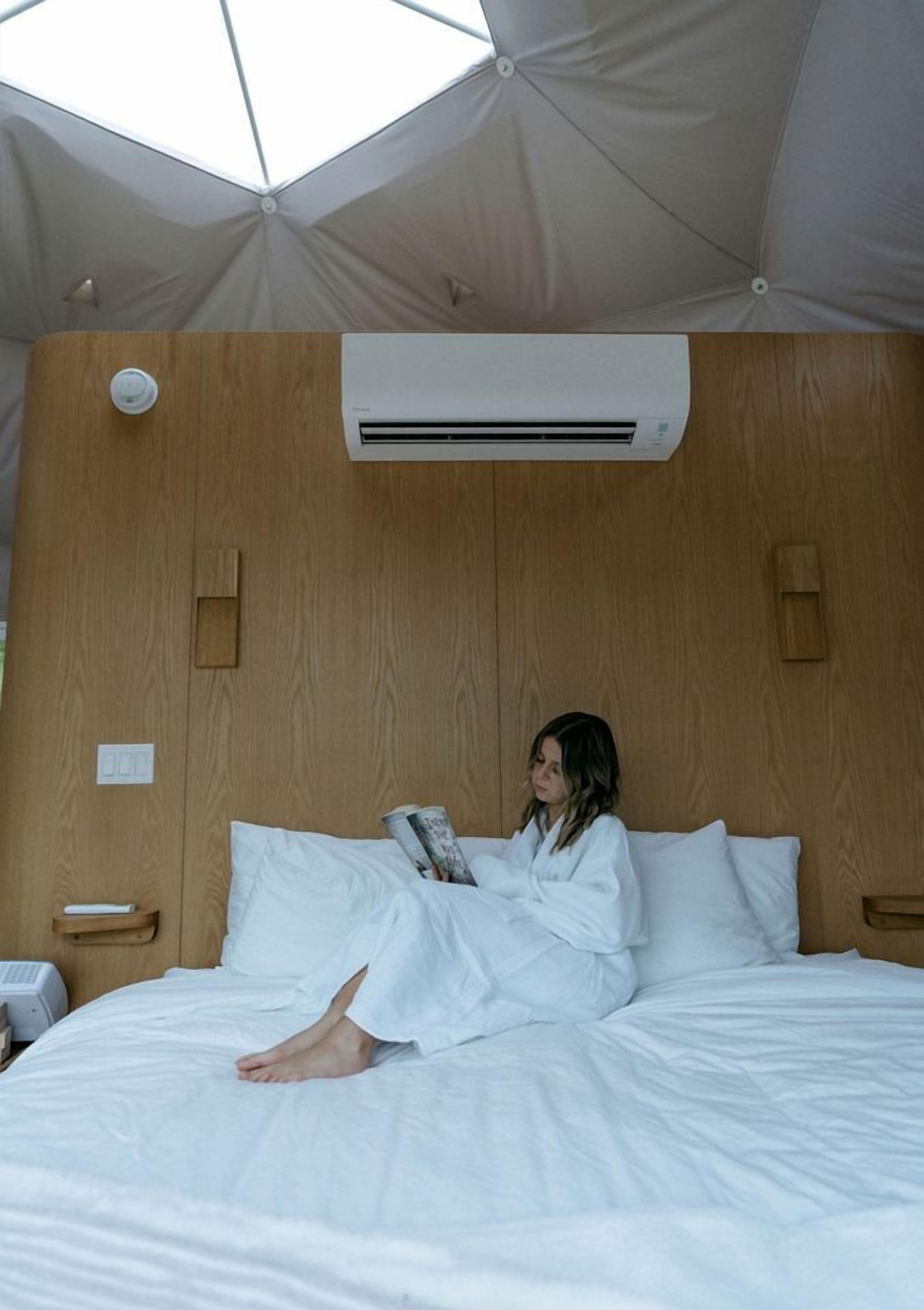 Ein Zimmer mit einem Bett, einer Klimaanlage und einem Dachfenster.