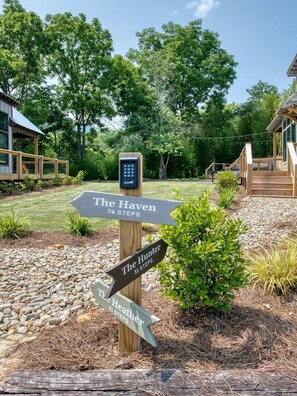 A wooden signpost with directional arrows to 'The Haven' and 'The Hunter,' indicating a walking path. - Spectacular Lofted Tiny House with Jacuzzi and Deck in North Carolina (Waynesville)