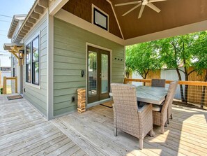 Un patio techado con una mesa y sillas, una puerta y una ventana.