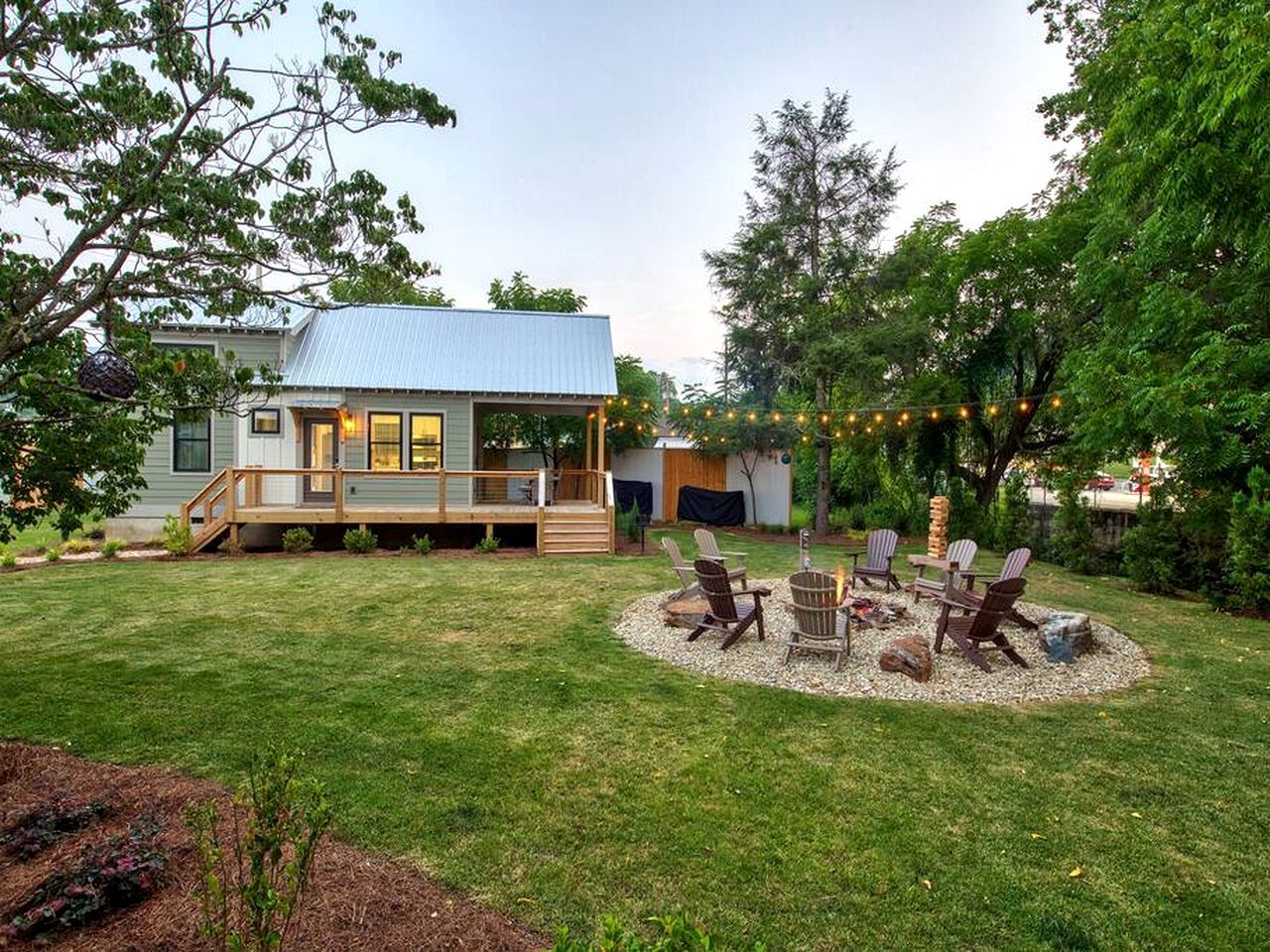 Uma casa com varanda, lareira e área de estar externa.