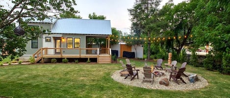 Een huis met terras, vuurkorf en buitenmeubilair.