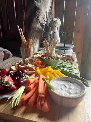 Une table en bois sur laquelle se trouvent divers aliments et un bol de sauce pour tremper.