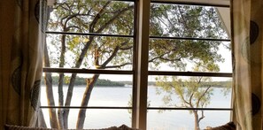 A window with a view of a lake and trees.