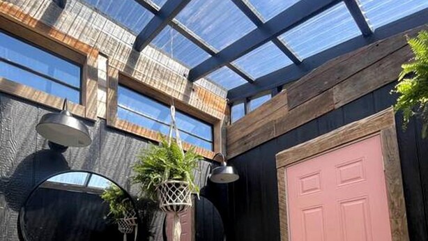 A greenhouse with a metal sink, wooden bench, and a pink door. - Romantic Stargazing Retreat: Bell Tent for Couples in Michigan's Dream Destination (Boyne Falls)
