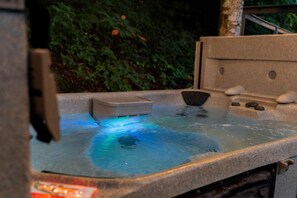 A hot tub with a stone exterior and a small control panel.