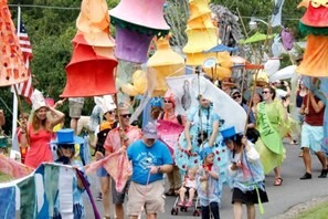 A group of people in a parade with colorful umbrellas and flags. - Experience Unrivaled Luxury: Exclusive Dome with Hot Tub and Unique Views in North Carolina (Todd)