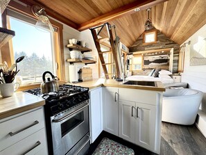 A kitchen with a stove, oven, and wooden cabinets.