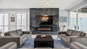 Una sala de estar moderna con chimenea, dos sofás y una mesa de centro.