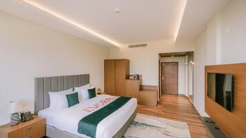 A hotel room with a bed, bedside table, TV, and a walk-in closet.
