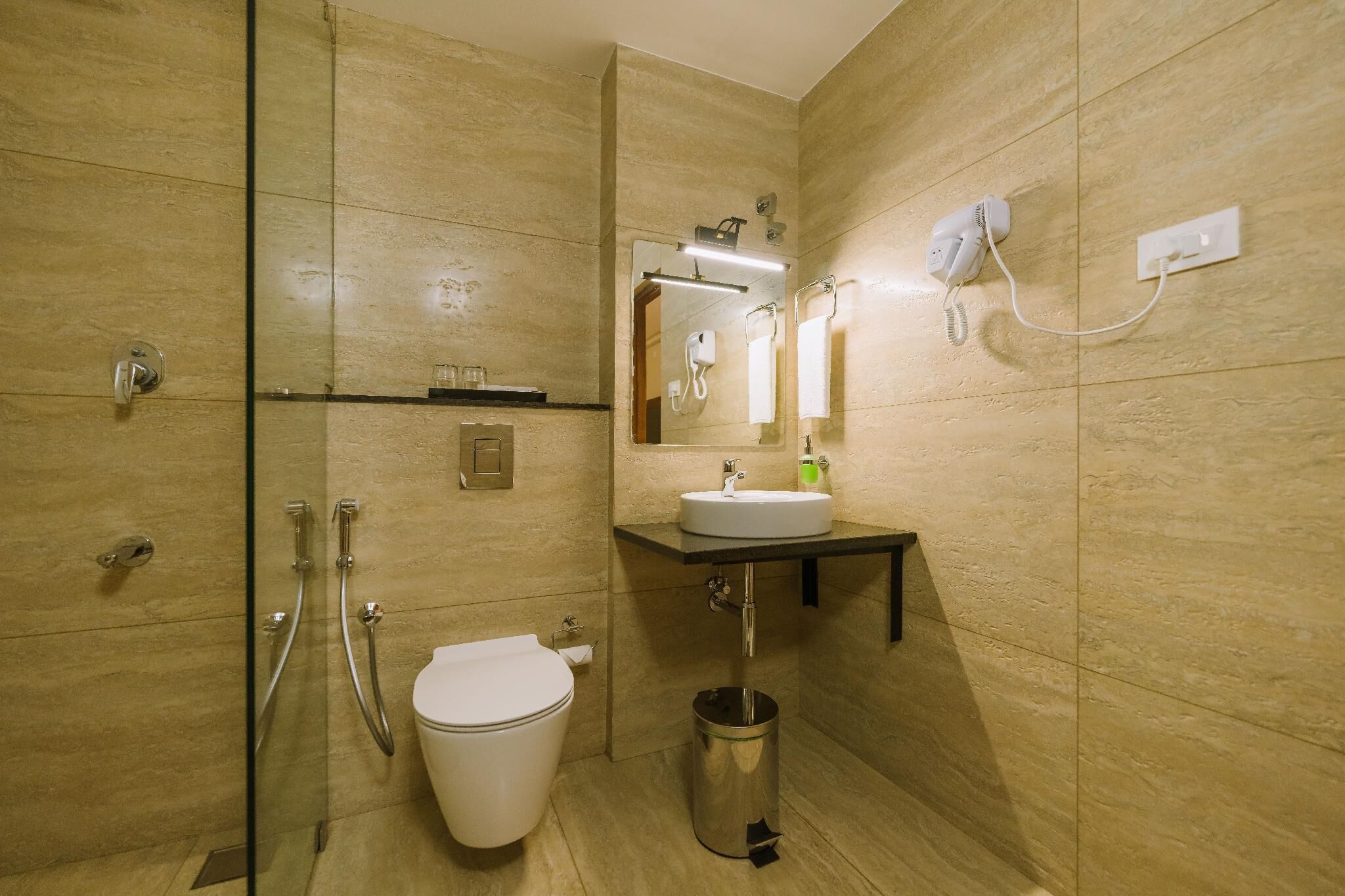 Ein Badezimmer mit Toilette, Waschbecken, Spiegel und Dusche.