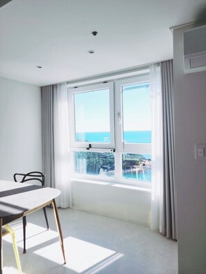 A room with a large window, a table, and a chair. - Lovely 1-bedroom apartment with AC in vibrant 부산 (부산)