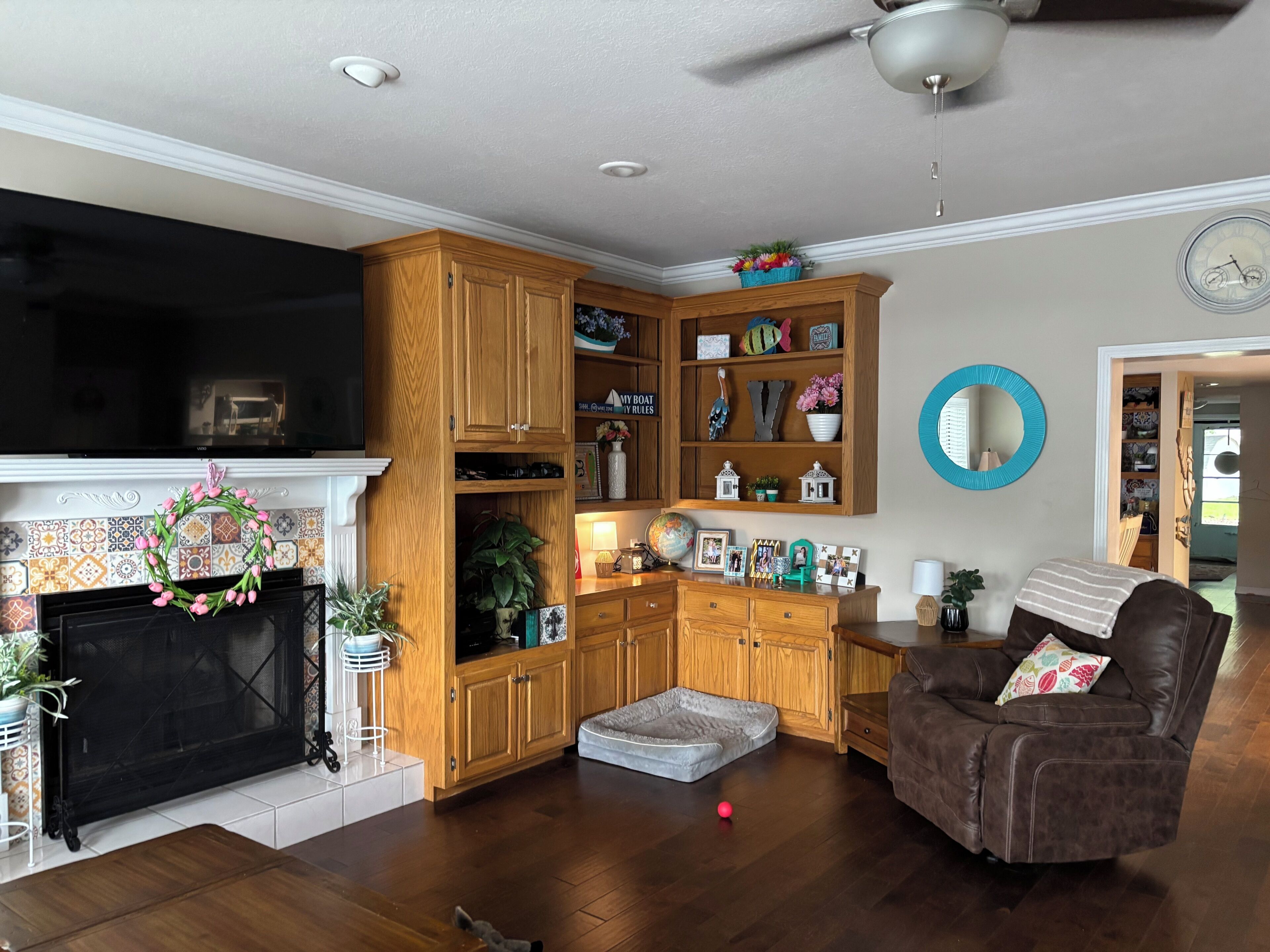 A living room with a fireplace, wooden cabinets, a leather sofa, and a globe on a shelf.