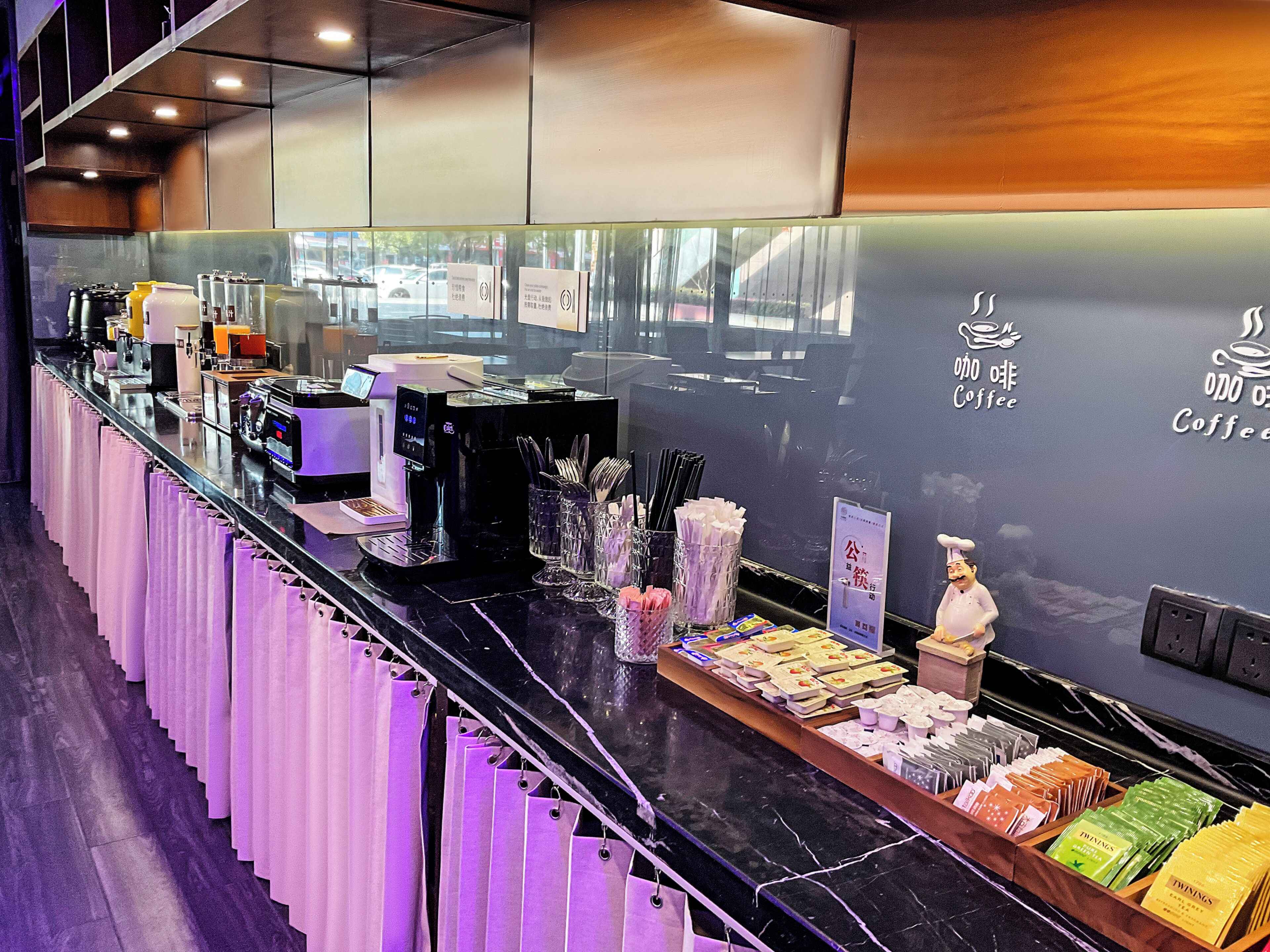 Ein Café-Interieur mit einer Theke, Kaffeemaschinen und einer Präsentation von Kaffeeprodukten.