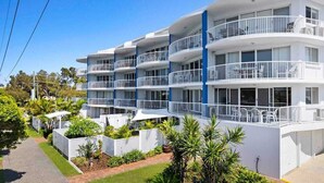 A multi-story hotel with balconies, a paved driveway, and landscaped gardens. - 7 Coral Seas 35-37 Sixth Avenue (Maroochydore)