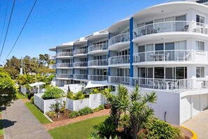 A multi-story hotel with balconies, a paved driveway, and landscaped gardens. - 7 Coral Seas 35-37 Sixth Avenue (Maroochydore)