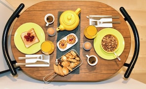 A breakfast table with toast, pastries, a teapot, and a bowl of cereal. - Studio Racapidi for Two in Unesco town Corfu (corfu)
