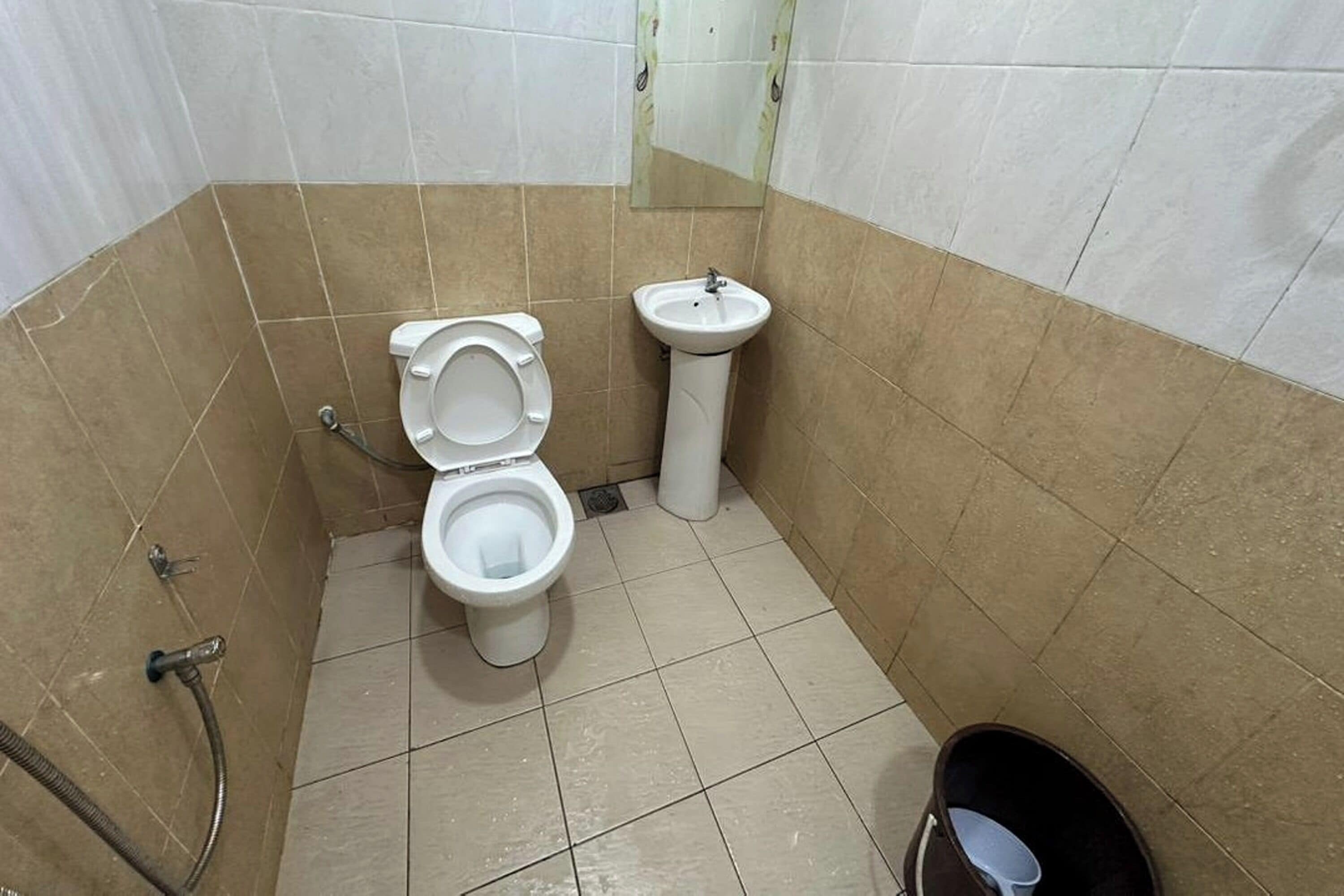 Un baño pequeño con inodoro, lavamanos y ducha.