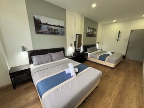 Una habitación de hotel con dos camas, un escritorio, una silla, un aparador y una puerta.