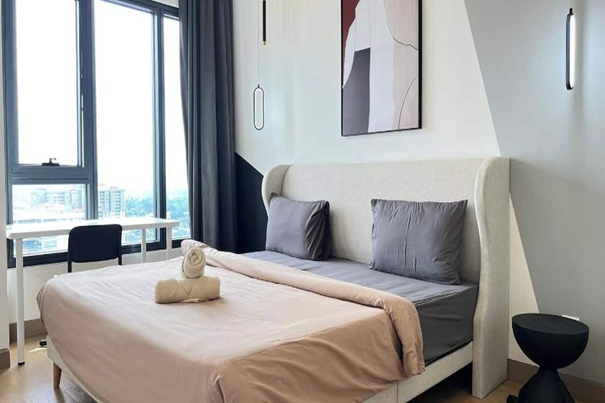 Un dormitorio moderno con una cama, un escritorio y vistas a la ciudad.