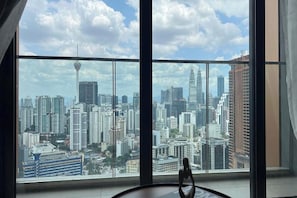 Habitación en un rascacielos con vistas panorámicas de la ciudad a través de amplios ventanales.