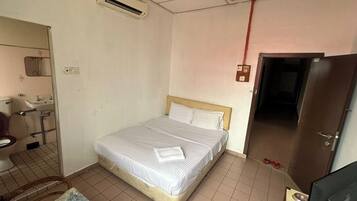 Une chambre à coucher avec un lit, un miroir, un lavabo et une porte.