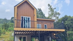 A two-story building with a balcony, a staircase, and a hammock. - Sawasdee@Ramrom (Ron Phibun)