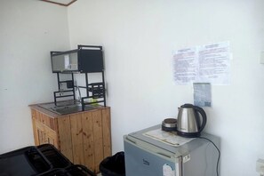 A kitchenette with a coffee machine, a kettle, and a small refrigerator. - Rai Doi Chang Moncham (Mae Rim)