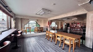 A modern interior with a bar area, seating, and kitchen space. - Nonoteru Chiang Mai Kamphaeng Din (Chiang Mai)