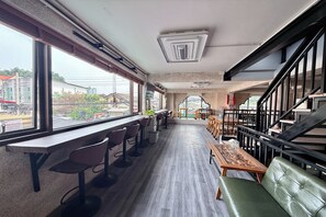 Ein modernes Interieur mit einer langen Bar, Sitzgelegenheiten und einer Treppe.