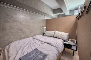 Et moderne hotelværelse med en stor seng, et natbord med en lampe og udsigt til himlen gennem vinduet.